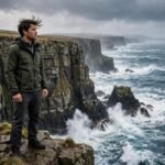 Person standing at sea cliffs facing ocean waves for courage quotes